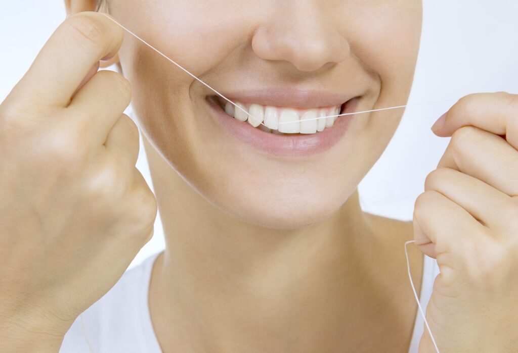 Girl flossing her teeth